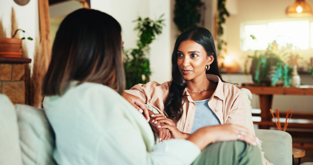 Happy, talking and friends with women on sofa for bonding, gossip and social reunion Discussion, advice and listening with people in living room at home for chat, news and connection together