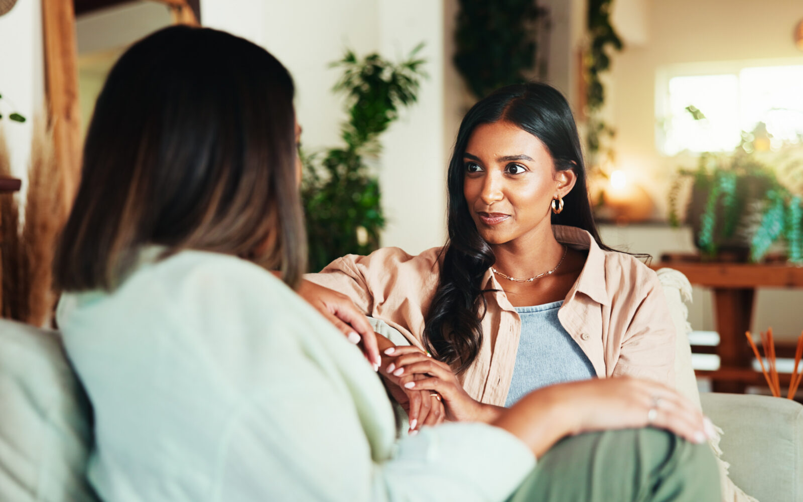 Happy, talking and friends with women on sofa for bonding, gossip and social reunion Discussion, advice and listening with people in living room at home for chat, news and connection together