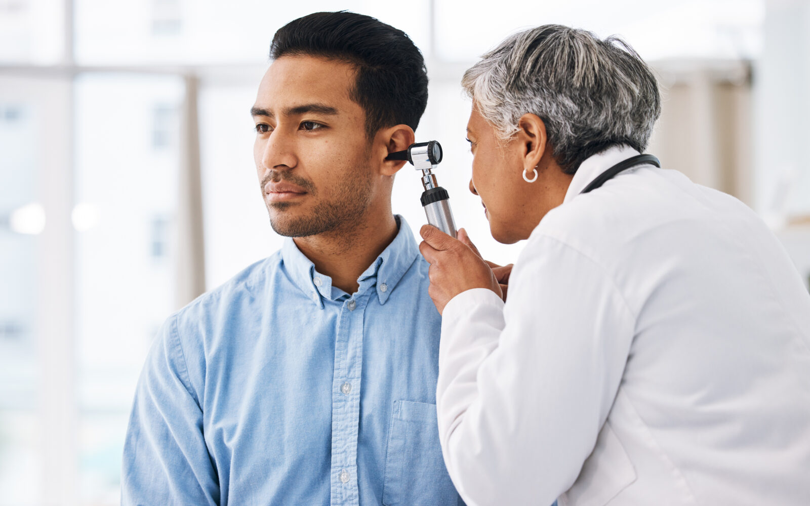 Doctor check patient ear, consultation and healthcare, people at hospital with otolaryngology specialist Man and senior physician woman with otoscope test for hearing problem and health insurance