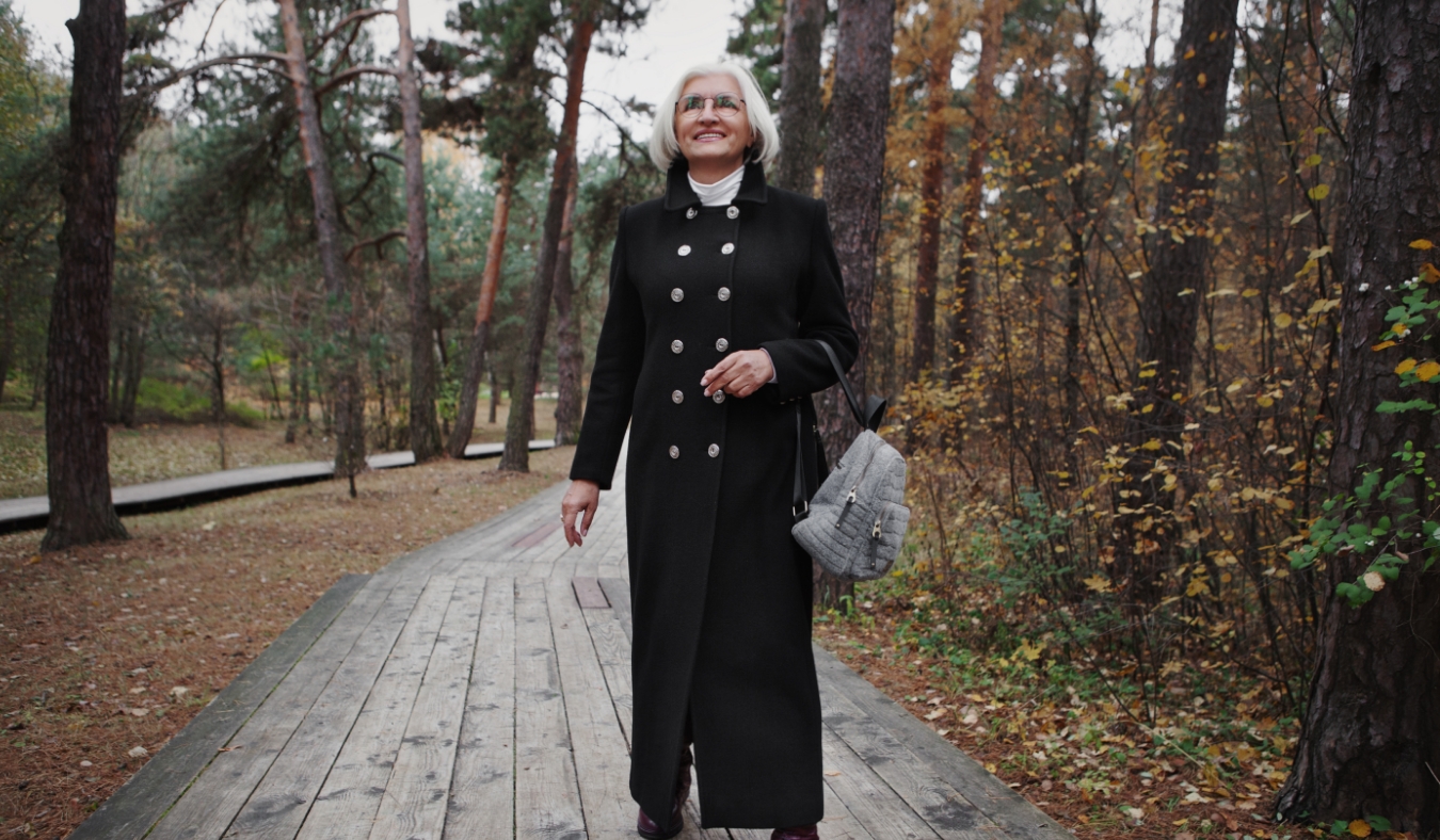 senior woman walking during brisk morning in wool coat