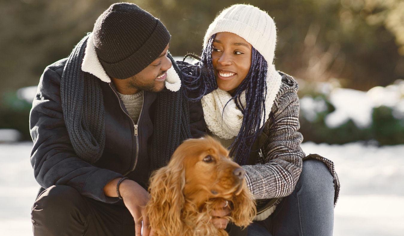 couple walking dog on a snowy day