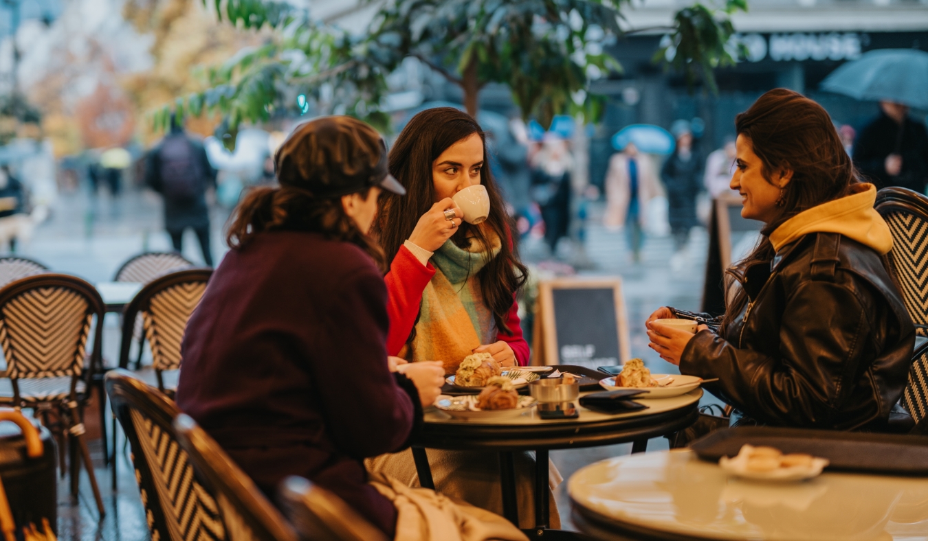 friends having coffee at an outdoor cafe on a winter day