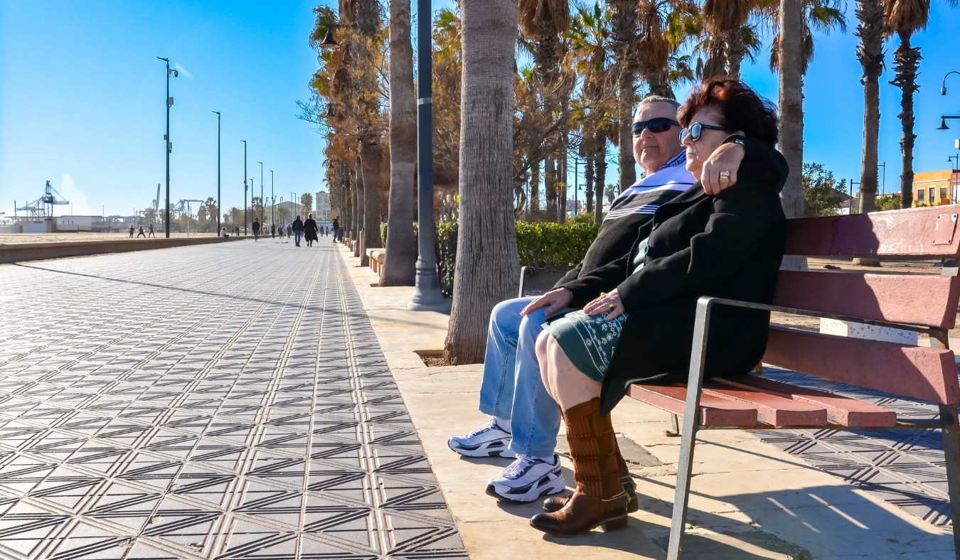 senior couple sitting in park on a colder day