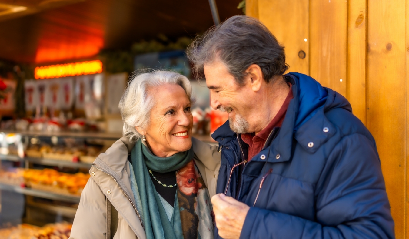 senior couple smiling outside a bakery