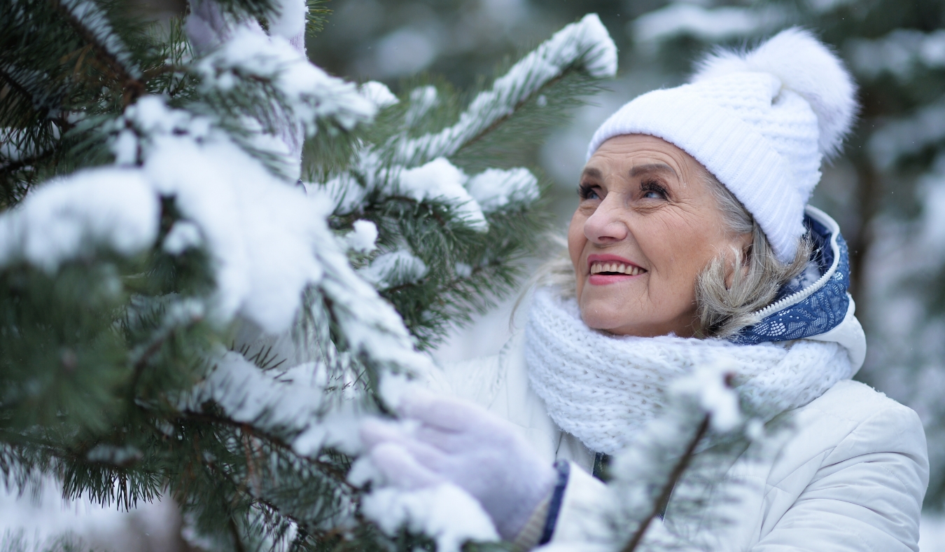 senior woman appreciating snowy branches