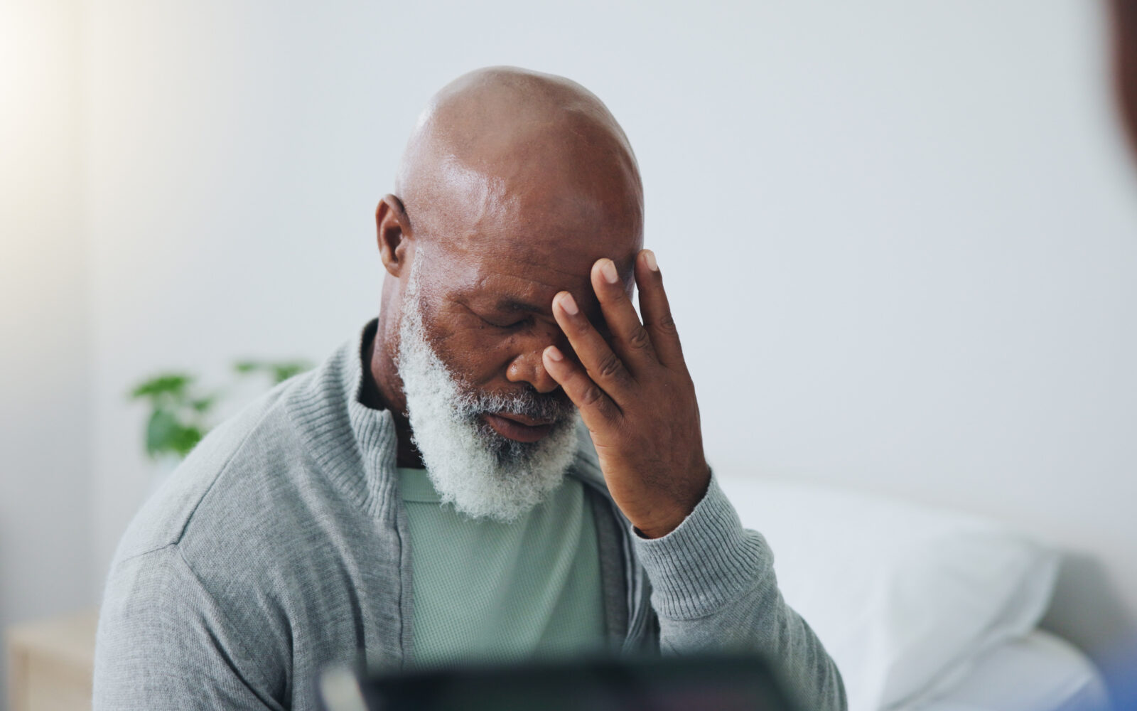 African American senior male holding his head from dizziness