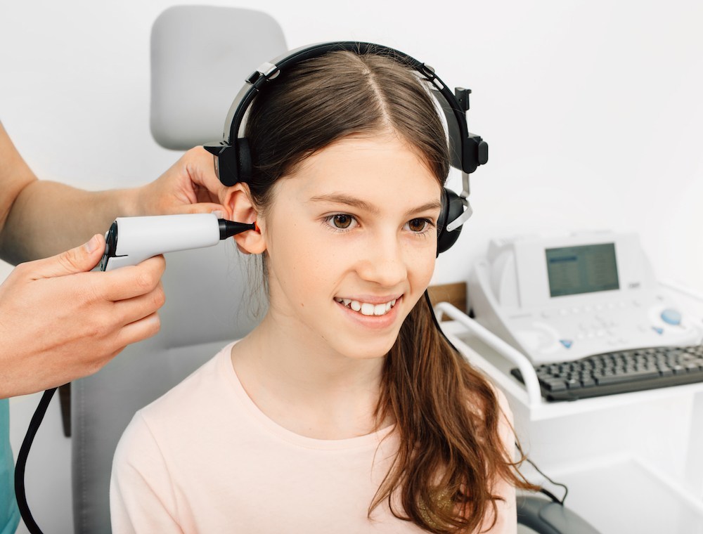 young child smiling during her hearing test