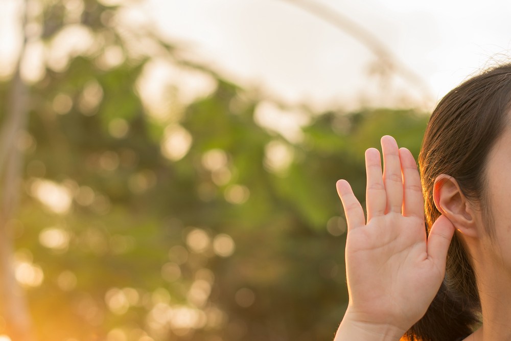 side of woman's head with hand