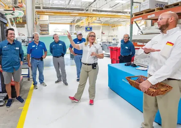 A regulator employee speaks to people touring the facility