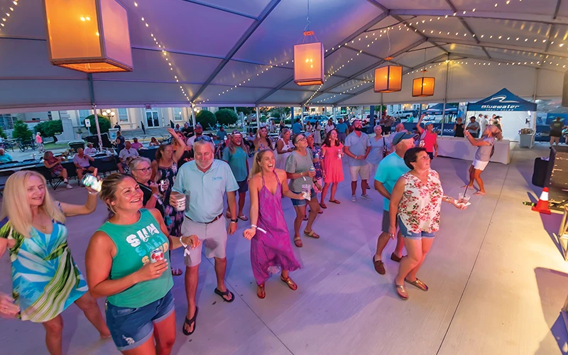 Safe Harbor Members and Bluewater guests dance under the tent during the evening cocktail party