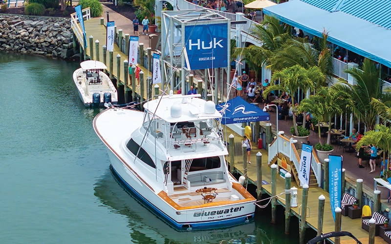 Bluewater's Viking 64 docked at a bustling tournament marina with branded flags on display