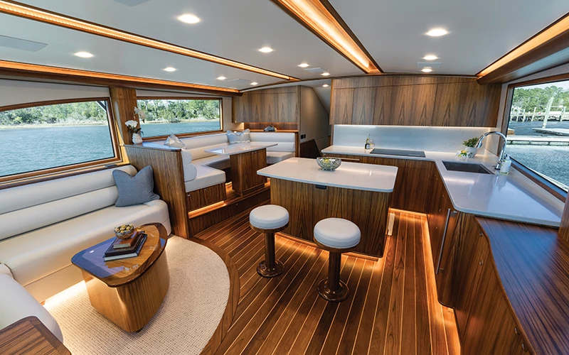 Luxurious interior of the Jarrett Bay 68 with satin-finished teak, L-shaped seating, and fully equipped galley