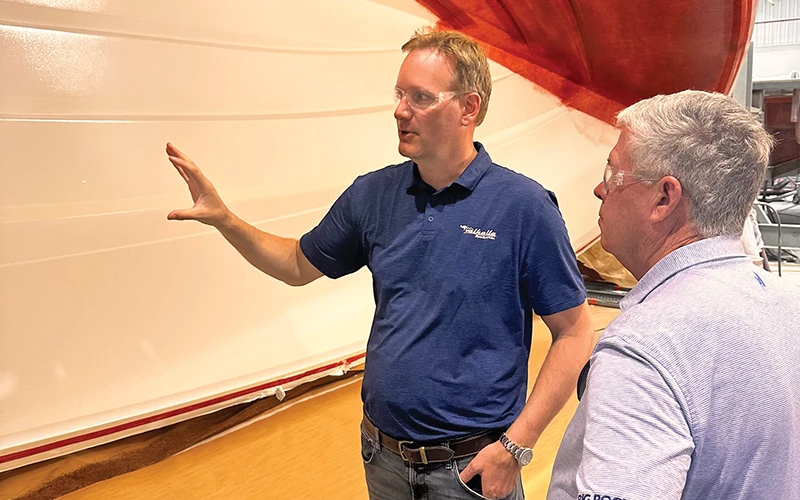 John Leek IV explaining hull construction details to John Donoghue during a factory tour of the Valhalla facility
