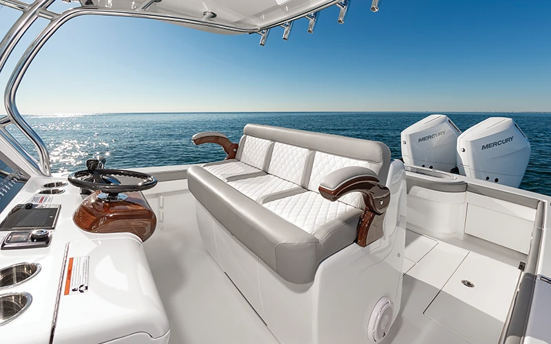Close-up of the Valhalla V-33 helm seating with diamond-stitched upholstery and Mercury outboards in the background