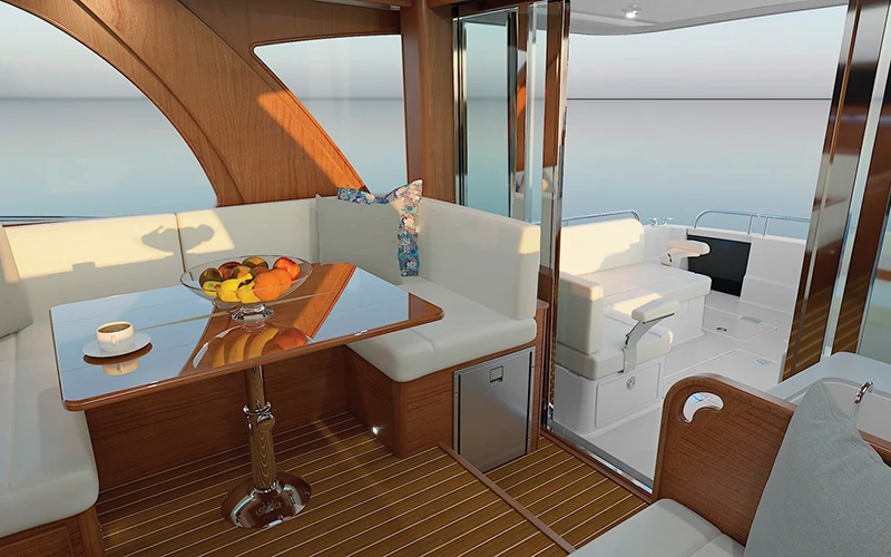 Interior salon of the Sabre 51 featuring handcrafted woodwork, L-shaped seating, and a high-gloss dining table