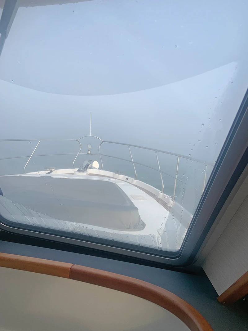 View from inside the pilothouse looking out onto the bow of the Elling E4 as it moves cautiously through dense fog