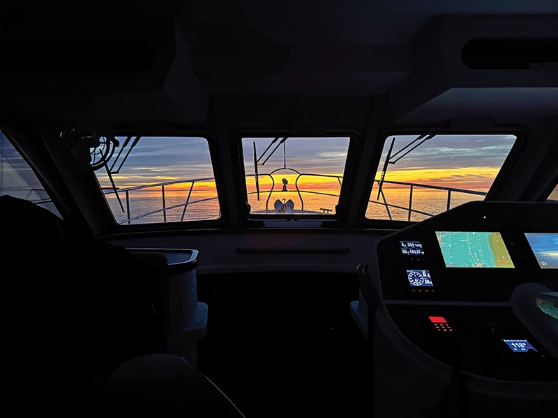 Stunning sunrise visible through the forward windows of the Elling E4’s pilothouse while underway
