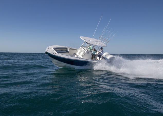 Regulator 25 center console boat banking into a turn at speed with anglers on board and fishing rods mounted in the rocket launcher