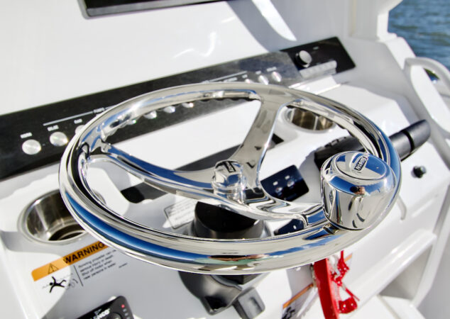 Close-up of polished stainless steel steering wheel with turning knob