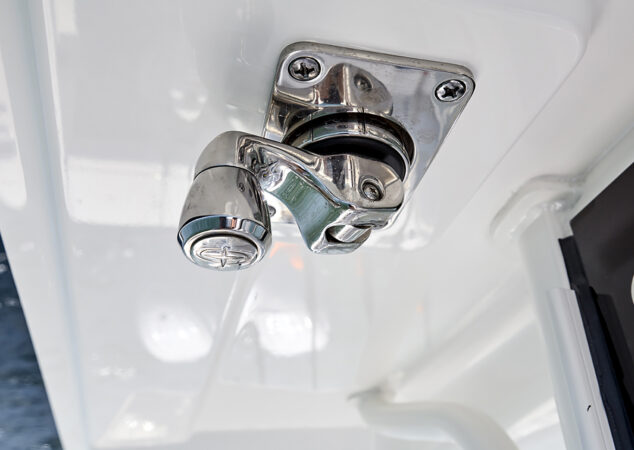 Polished stainless steel latch mechanism mounted on the T-top frame