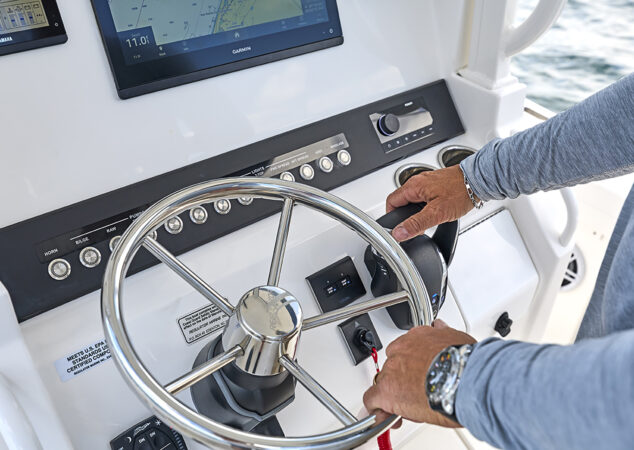 Man with hands on throttle and stainless steering wheel of Regulator 23