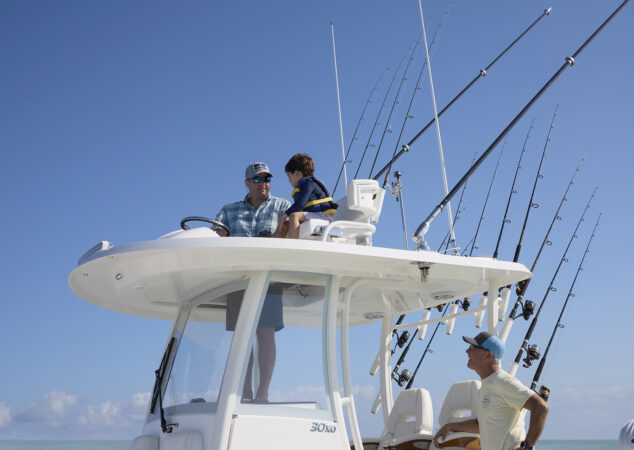 Close-up of the upper station on the Regulator 30XO, with a father and child seated at the helm