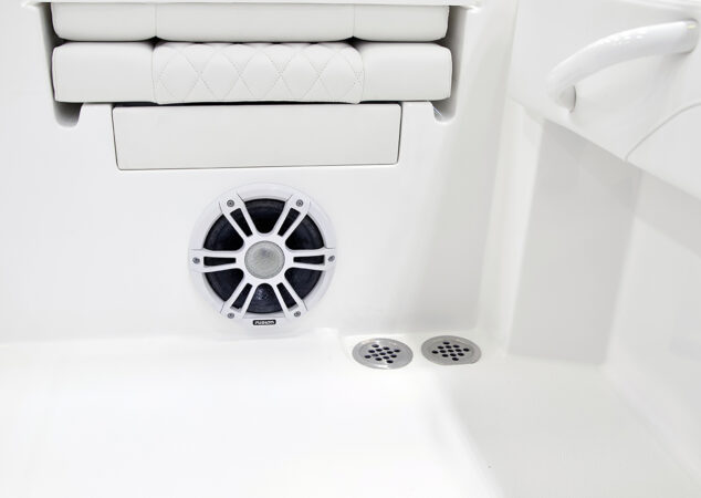 Fusion marine speaker and dual deck drains set into the white interior of the Regulator 30XO