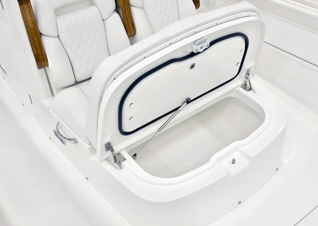 Forward console seating with teak armrests, shown with integrated storage compartment open