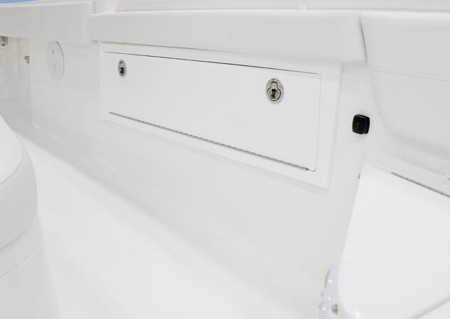 Flush-mounted side storage compartment with locking latch inside the cockpit