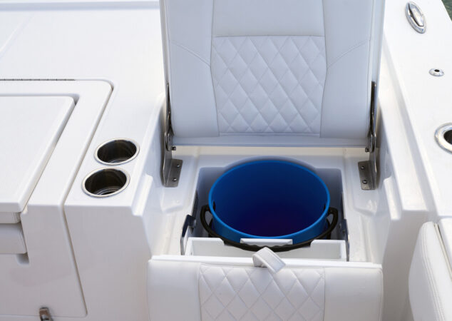 Aft cockpit seat flipped open, showing a blue bucket insert with twin Yamaha outboards behind