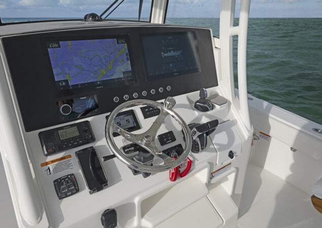 Main helm station featuring twin Garmin multifunction displays, stainless wheel, and Yamaha controls