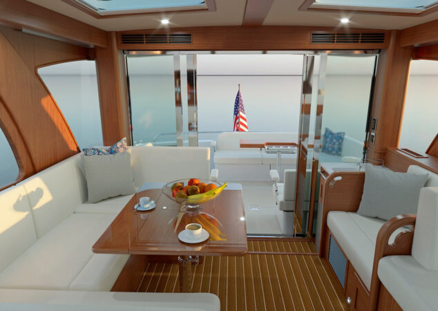 Bright salon of the Sabre 51 featuring wraparound seating, wood accents, and a high-gloss table set with fruit and coffee