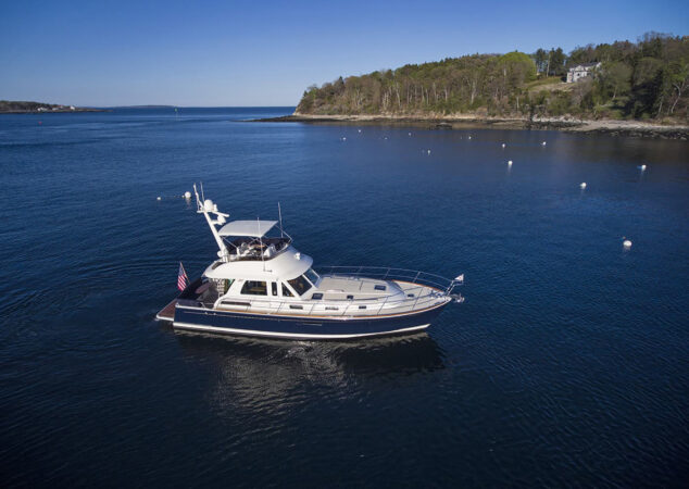 Aerial view of Sabre 48 Fly Bridge floating on calm water, with shoreline and buoys surrounding