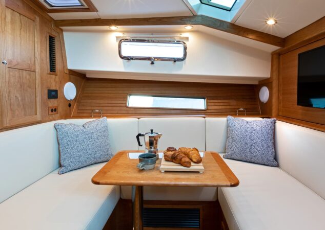 Lower dinette on the Sabre 43 SE with U-shaped seating, wood table and portlights
