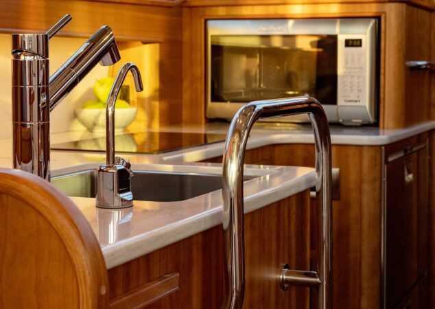 Sabre 43 Salon Express galley detail with stainless sink, solid-surface counter, handrail and convection microwave
