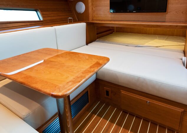 Lower dinette converting to a guest berth on the Sabre 43 SE with high-gloss table and cream cushions