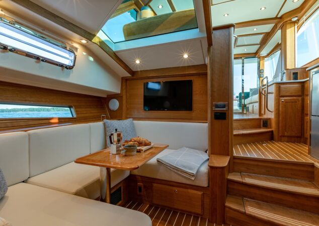 Lower salon dinette on the Sabre 43 with skylights overhead and steps leading up to the galley and helm