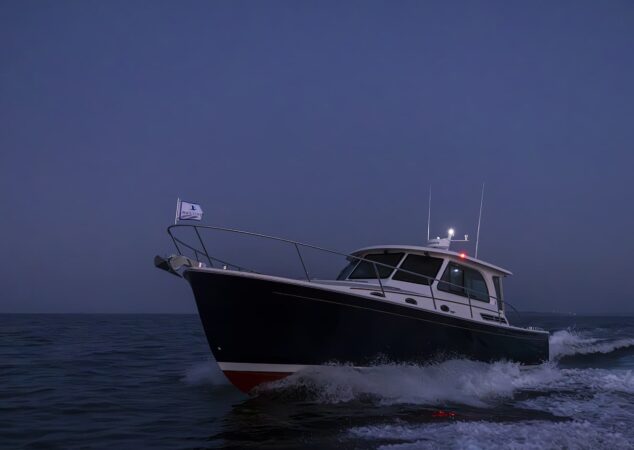 Back Cove 412 running offshore at night with navigation lights and bow flag visible
