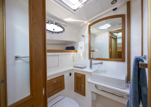 Back Cove 412 guest head with vanity sink mirror and storage cabinets