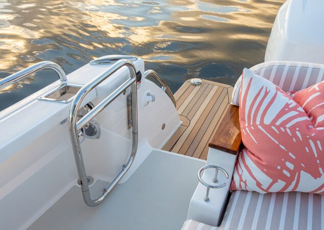 Close-up of the Back Cove 39O swim platform with stainless steel boarding gate and patterned cushions
