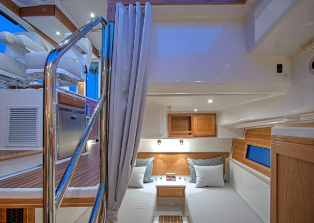 Guest cabin on the Back Cove 39O with twin berths, wood cabinetry, and curtain divider, viewed from the companionway