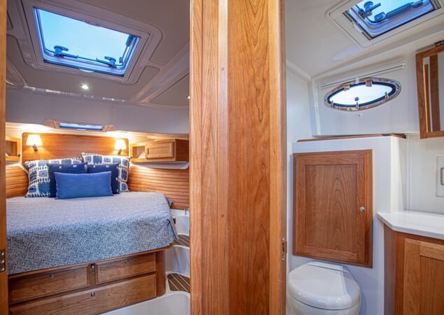 Master stateroom aboard the Back Cove 39O with queen berth, wood cabinetry, and private ensuite access to the head