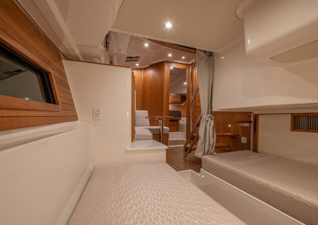 Lower twin berth cabin of the Back Cove 39O with wood cabinetry, curtain divider, and steps leading to salon