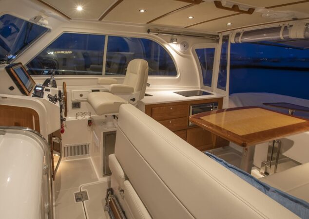 Helm station and seating area of Back Cove 34O illuminated at night