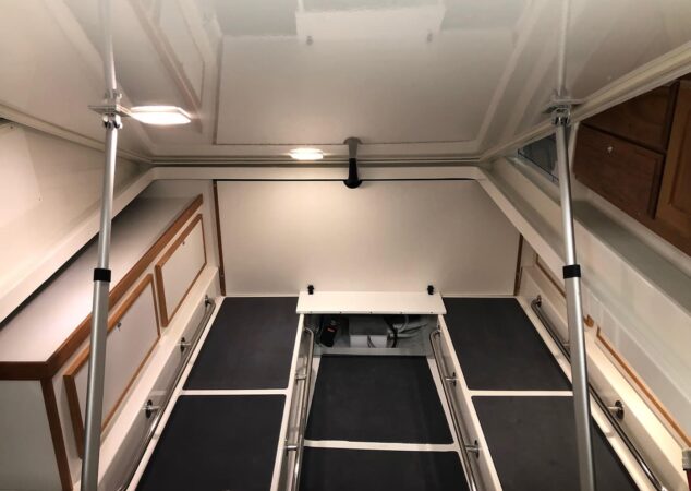 Storage and access area beneath the cockpit deck on the Back Cove 34O, with equipment space and lined compartments