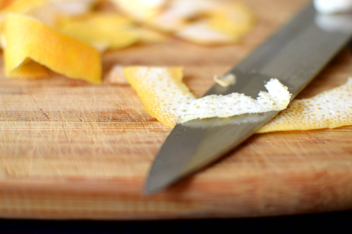 Removing the pith from lemon peel.