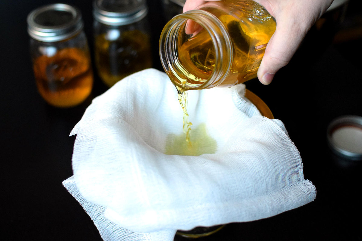 Straining the Limoncello through cheesecloth.