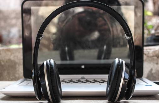 Photo of a laptop and headphones