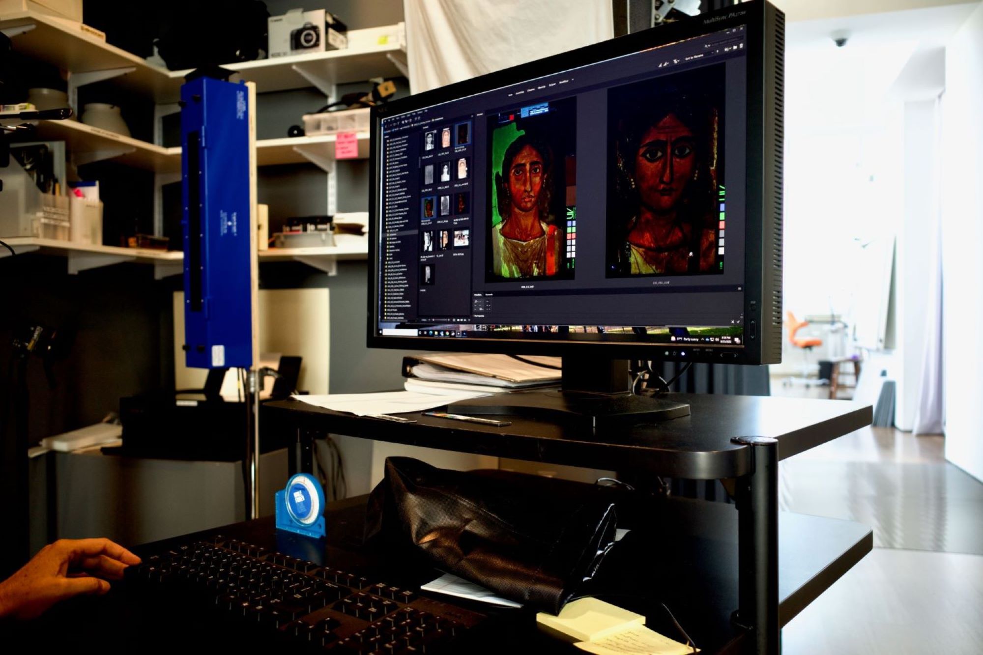 Two photographs are side by side. At left, a dimly lit laboratory shows a computer monitor, on which appears diagnostic images of a female funerary portrait. At right is a photograph of an X-ray showing a panel with a schematic oval face in the center; numerous white lines radiate from the edges.