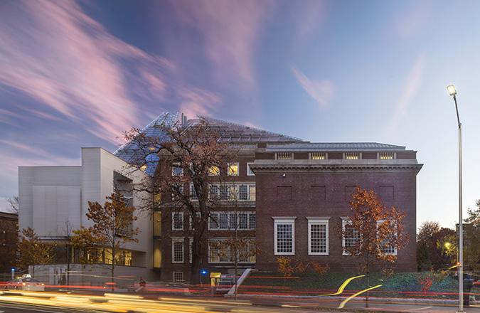 A long exposure photo showing the streaks of light from traffic and clouds surround the museum building.